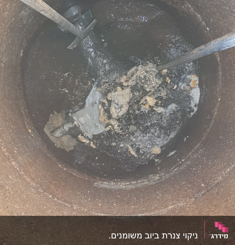 תא ביוב עם צינורות ושאריות פסולת